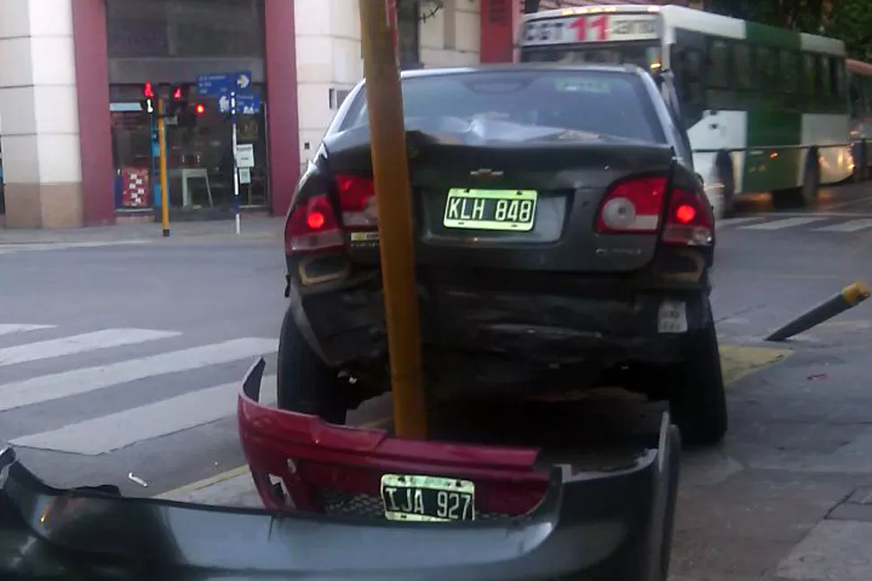 EN LA VEREDA. Uno de los autos se estrelló contra el semáforo de la Salta.