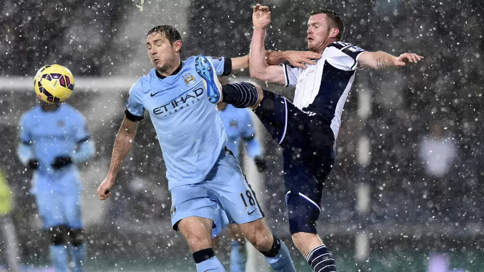 BAJO LA NIEVE. Manchester City, con Martín Demichelis como único argentino en cancha, derrotó bajo la nieve a West Bromwich por 3-1 y se mantuvo a tres puntos de diferencia del líder Chelsea. REUTERS.