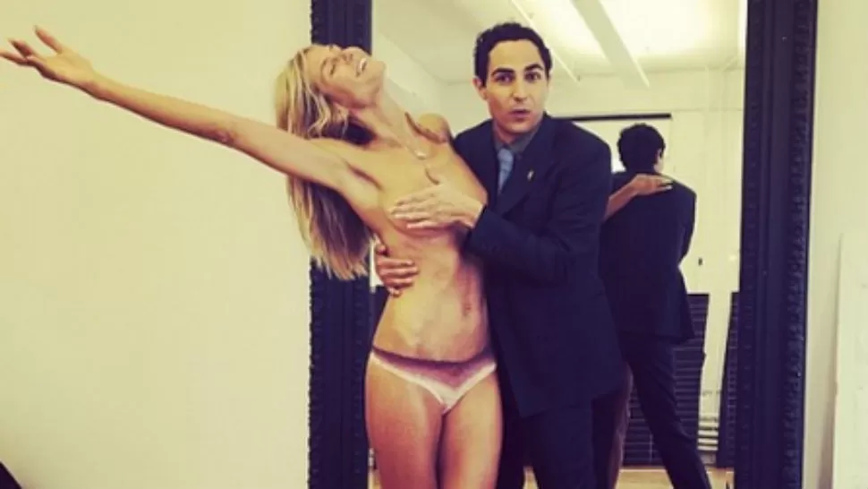 DIOSA.- El diseñador Zac Posen tapa las lolas de Heidi Klum, mientras ella pide algo para vestirse. Foto: Instagram.