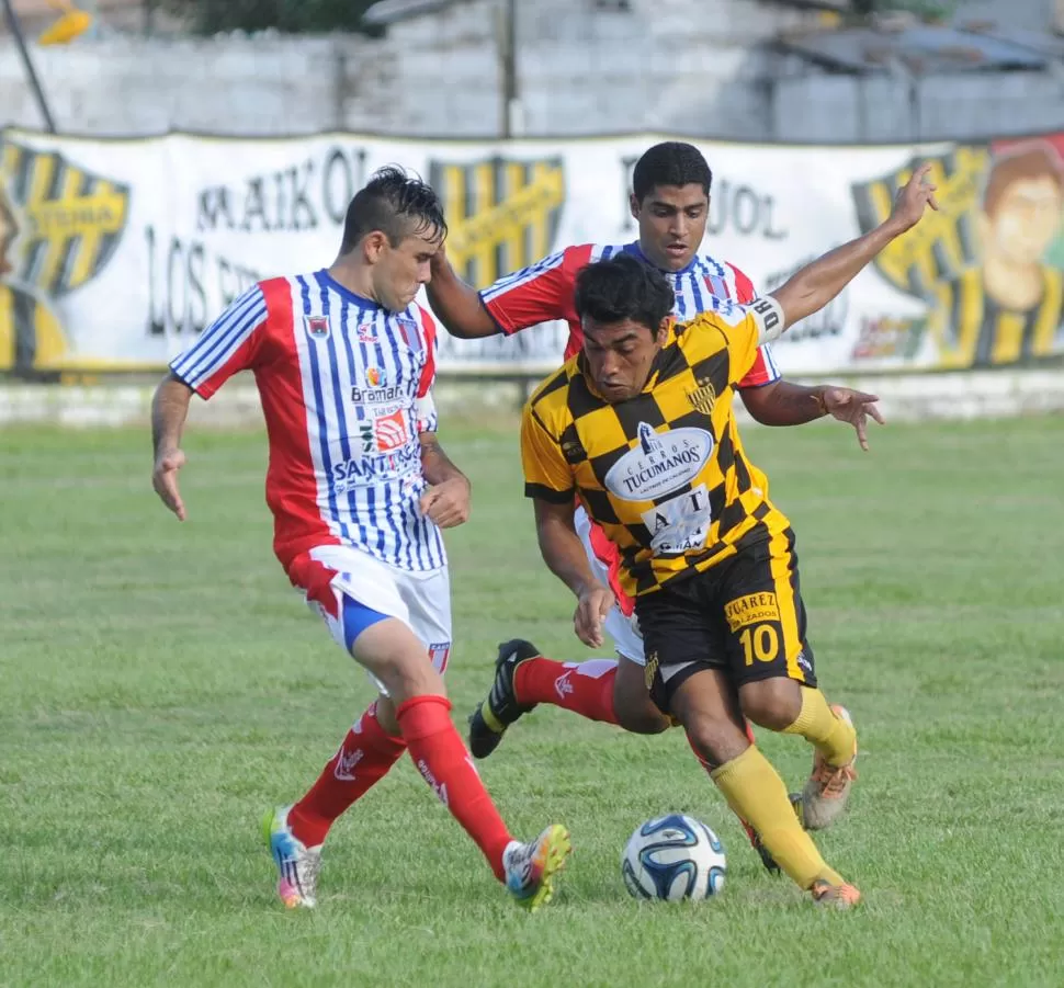 RODEADO. Juan Lubo se lleva la pelota a pesar de estar marcado por los centrales Javier Payla y Franco Rossi. LA GACETA / FOTO DE HÉCTOR PERALTA 