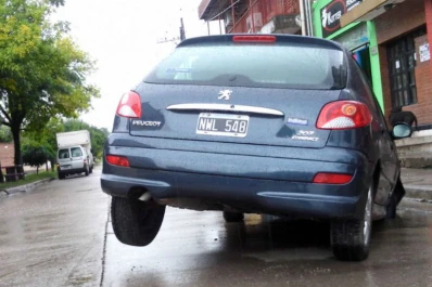 Por las calles inundadas, no vio el pozo y su auto se hundió