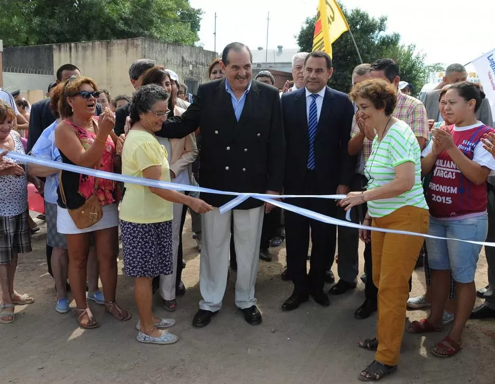 EN VILLA ANGELINA. El gobernador Alperovich sonríe mientras dos vecinas cortan la cinta para inaugurar el cordón cuneta, en Juana de Artaza al 500. 