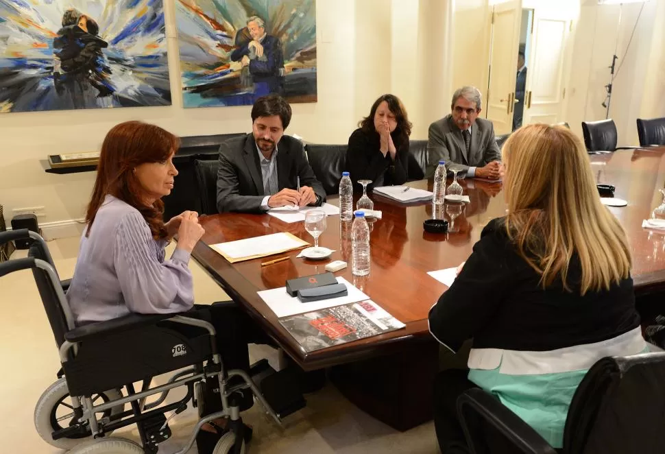 EN SILLA DE RUEDAS. La Presidenta y el secretario de Presidencia, Aníbal Fernández, recibieron ayer a miembros de Memoria Activa, asociación civil creada con el fin de esclarecer los atentados a la embajada de Israel a la AMIA. telam