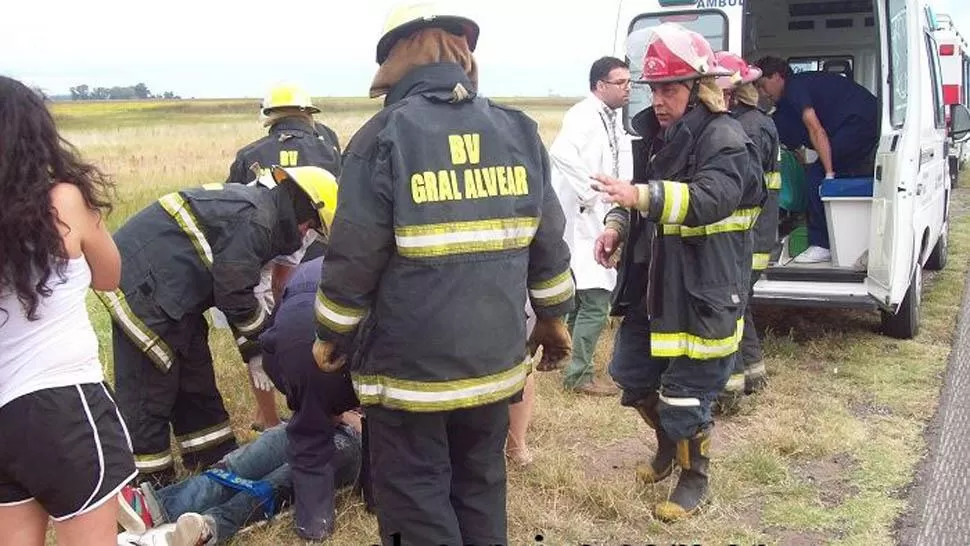 DOLOR. La Policía asistió a las víctimas, que quedaron tiradas a unos 15 metros a la vera de la ruta 205.  FOTO DE ALVEARVIVE.COM