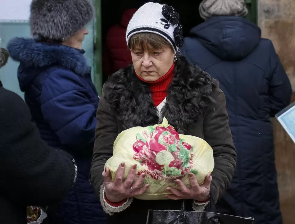 AYUDA HUMANITARIA. Una refugiada ucraniana retira alimentos. reuters