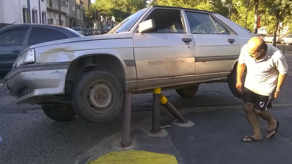 SUSPENDIDO. El auto quedó con dos ruedas al aire luego de llevarse por delante los postes. FOTOS ENVIADAS POR UN LECTOR