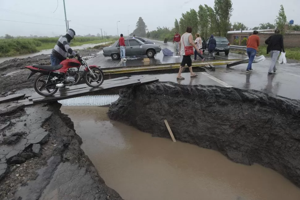 SUELO PANTANOSO .El lodo cubre todo el suelo. Abajo, la ruta 38 destruída para permitir el drenaje del río. la gaceta / fotos de franco vera 