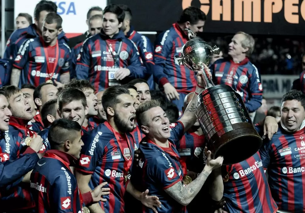 LA IMAGEN QUE QUEDÓ GRABADA EN LA HISTORIA. El ex Atlético Julio Buffarini levanta la Copa Libertadores que San Lorenzo logró el año pasado. El campeón debutará el miércoles 25 contra Danubio. dyn 