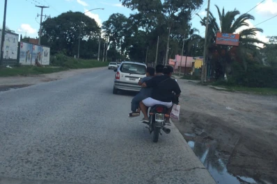 Llevan a un niño colgado de la moto