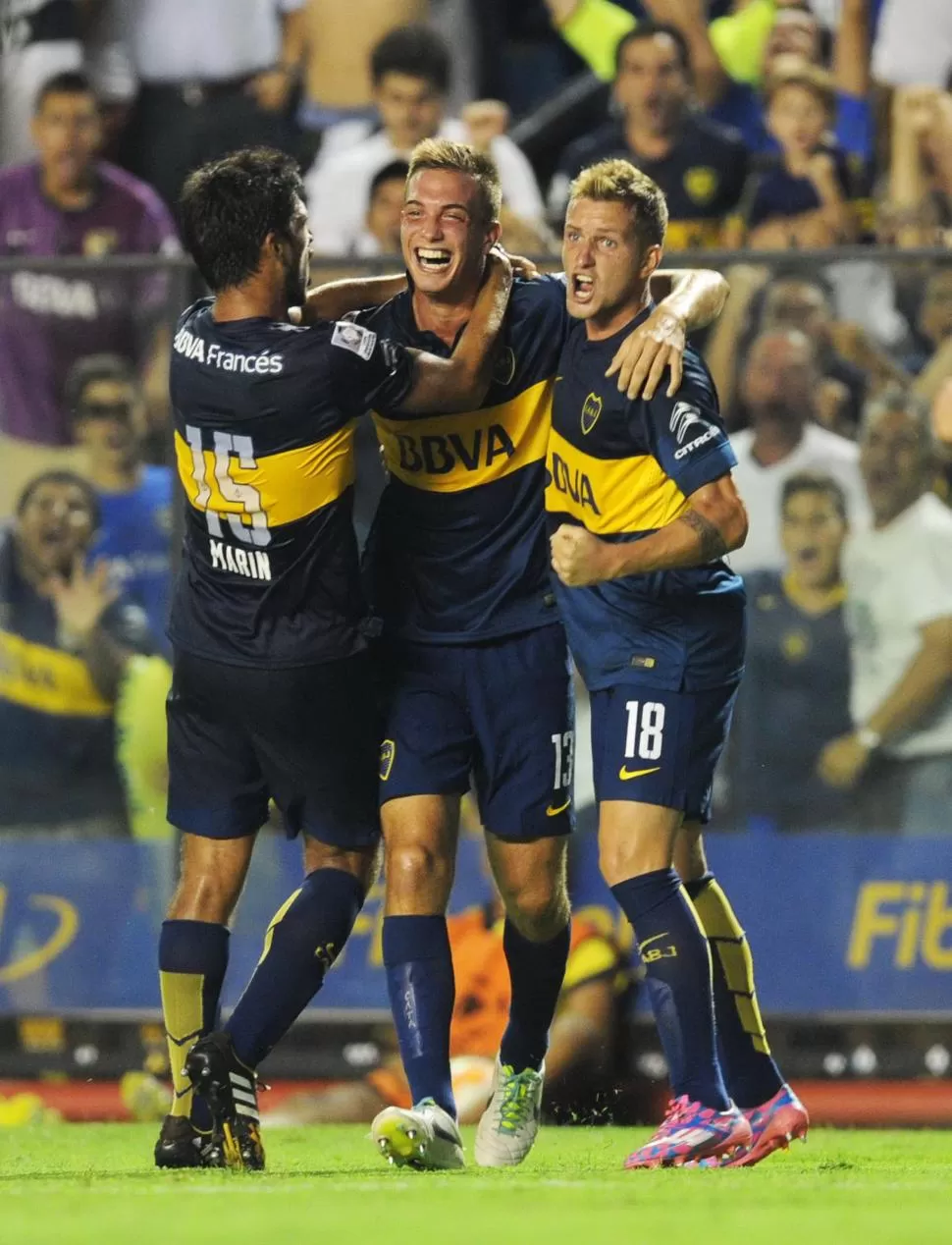 ¡QUÉ DEBUT! Juan Cruz Komar, que es felicitado por Marín (15) y por Colazo (18), reemplazó a Burdisso y marcó el primer gol. telam