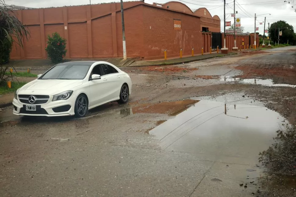  La Madrid, el automovilista tiene que elegir sobre cuál bache caer. En la esquina de esa senda con una cerámica, uno de esos cráteres mide 2,44 metros de largo, y tiene 13 centímetros de profundidad. 