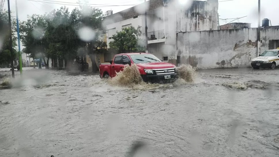 BAJO EL AGUA. Una camioneta 4x4 avanza por el cruce anegado de Chile y Junín. FOTO ENVIADA POR UN LECTOR