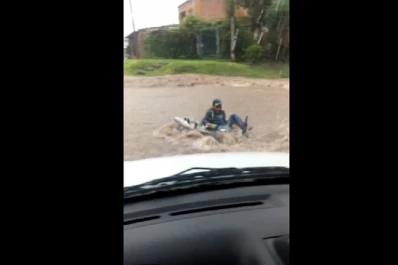 Quiso cruzar la calle con su moto y el agua se lo llevó