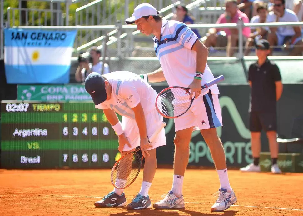 CONSUELO. Carlos Berlocq calma a Diego Schwartzman luego de una acción fallida. La dupla nacional no encontró la fórmula para frenar a los brasileños. télam