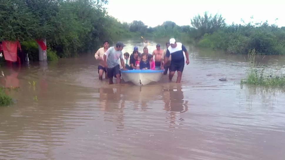 BAJO EL AGUA. Rescatistas asisten a una familia en la localidad de Atahona, en Simoca. FOTO ENVIADA POR UN LECTOR