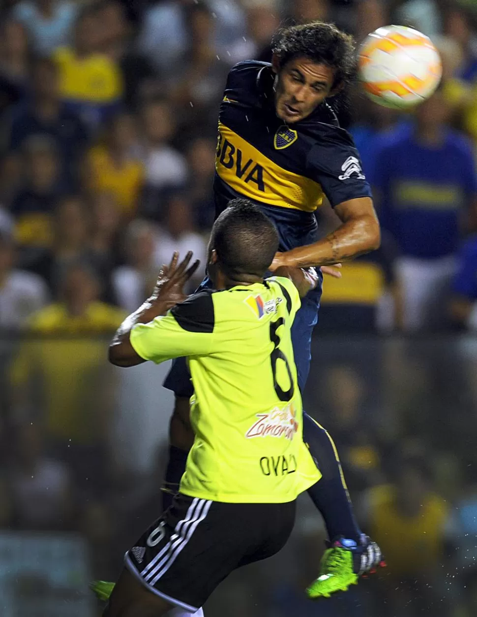  ABRIÓ EL CAMINO DEL ÉXITO. El volante César Meli, que anotó el primer tanto “xeneize”, le gana en lo alto a Luis Ovalle. TÉLAM