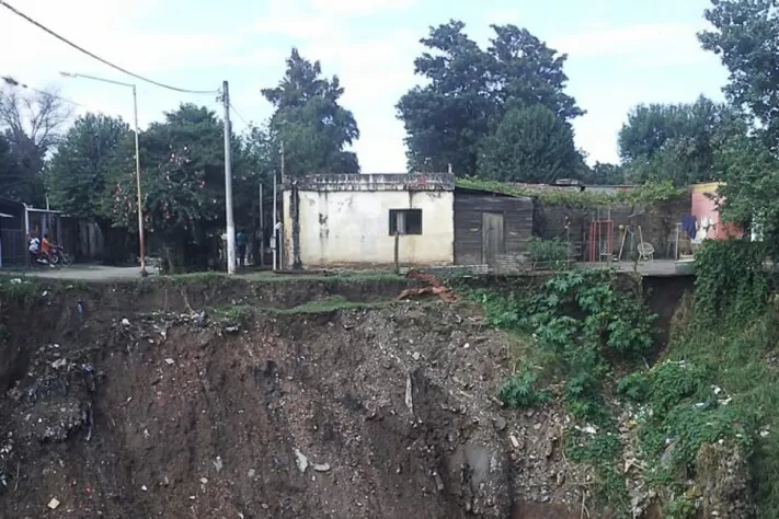 JUNTO A UN BARRANCO. La furia del agua desarmó un canal y comió los cimientos de un barrio; ya cayó una casa. FOTOS ENVIADAS POR UNA LECTORA