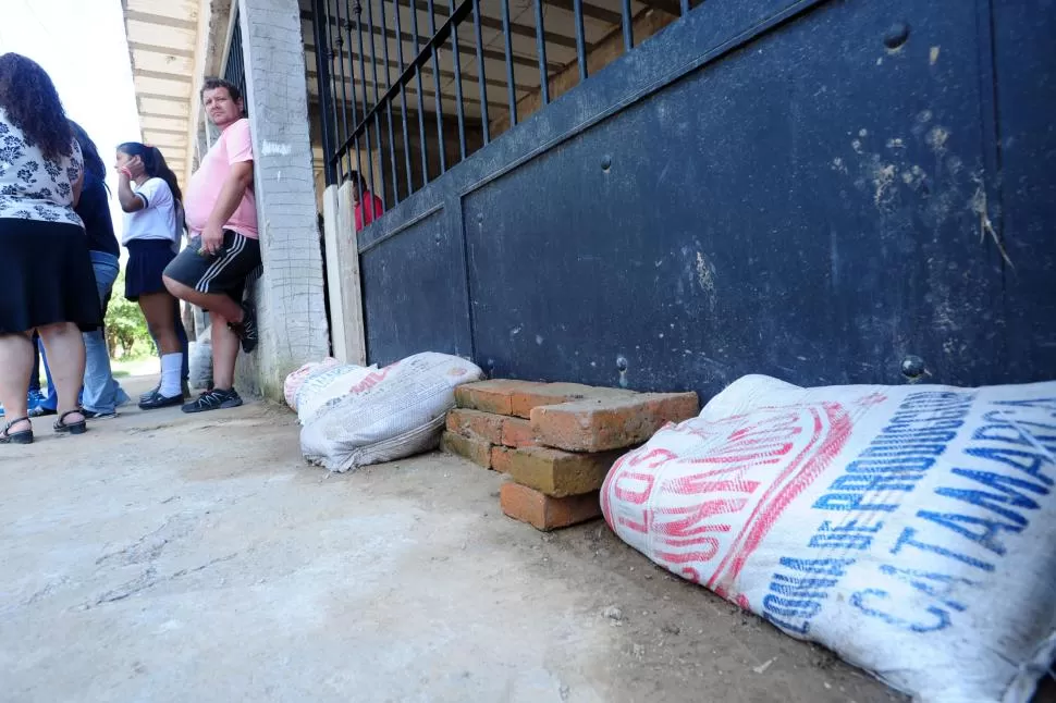 BOLSAS DE ARENA Y LADRILLOS. Los vecinos temen que el agua entre de nuevo en la próxima tormenta. 