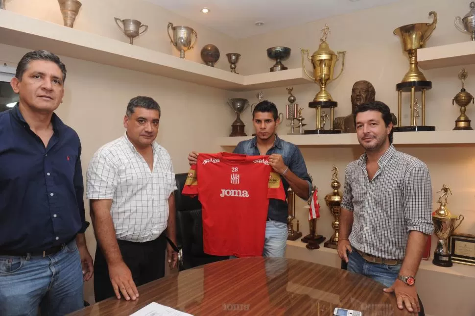 NUEVOS COLORES. “Nico” Carrizo posa con una chomba del “santo” tras firmar su contrato en las oficinas de La Ciudadela. la gaceta / foto de antonio ferroni