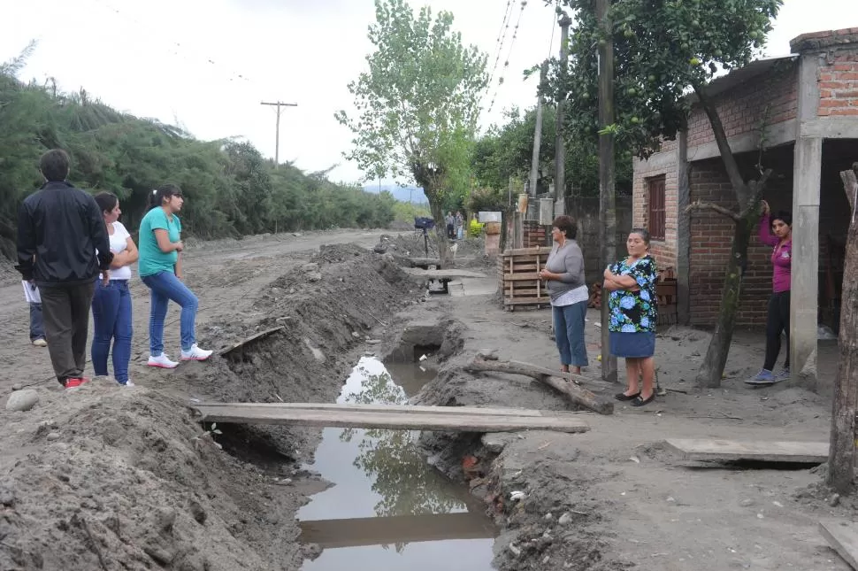 PUENTES IMPROVISADOS. Vecinos deben pisar maderas para llegar a su casa. 