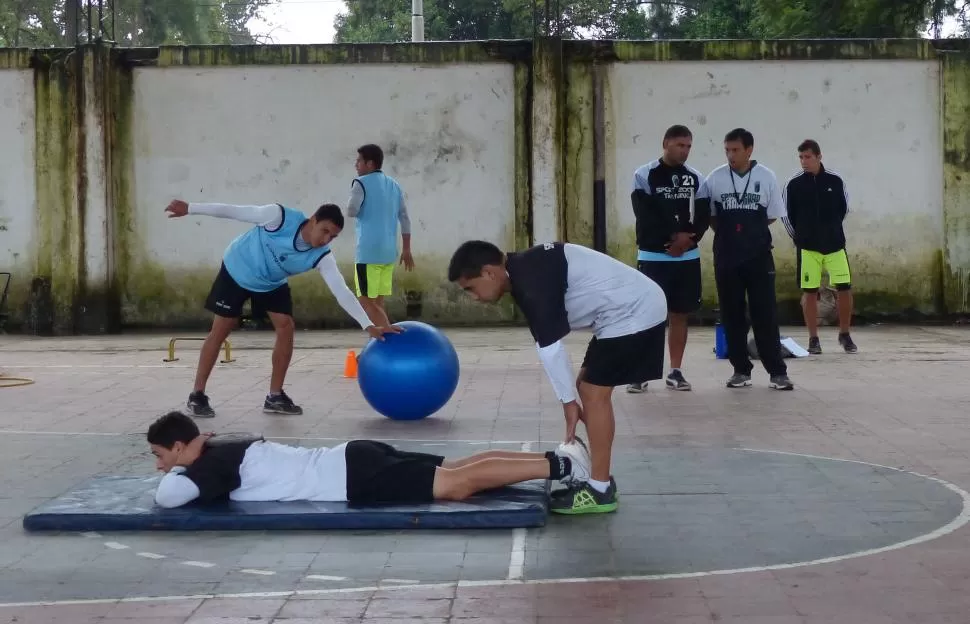 SUPERVISANDO TODO. Godoy charla con el profesor Elio Cabral, mientras los jugadores trabajan en la parte física.  la gaceta / foto de osvaldo ripoll