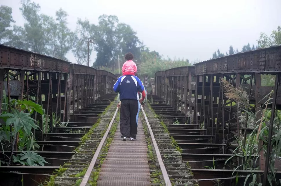 PELIGRO. Con ayuda de la Municipalidad y de los vecinos se armó una escalera para subir y bajar del puente ferroviario, que también colapsó. la gaceta / fotos de antonio ferroni