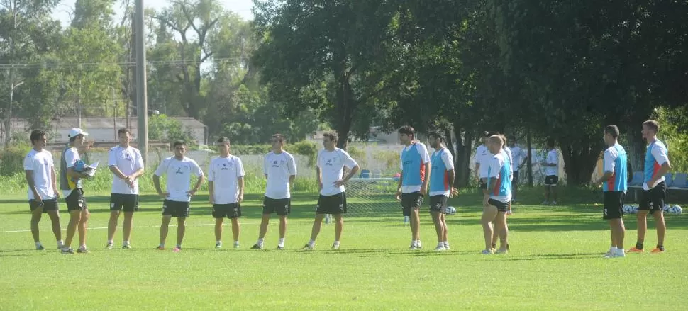  CONCENTRADOS. Azconzábal charla con parte titulares y varios suplentes durante un entrenamiento en el Complejo. El entrenador rotará a gran parte del equipo para el partido de esta noche con Santamarina. télam