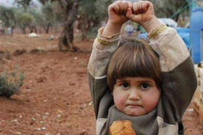 Una niña siria levanta las manos al confundir la cámara con un arma