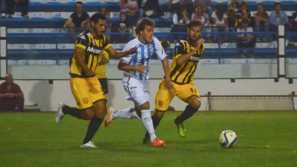 RODEADO. Quiroga intenta llevarse el balón ante la persecución de Gáspari (11) y de Scoppa. El “decano” tuvo un partido intermitente y su rendimiento fue bajo. foto de RAUL CABRERA LA VOZ DE TANDIL (especial para la gaceta)