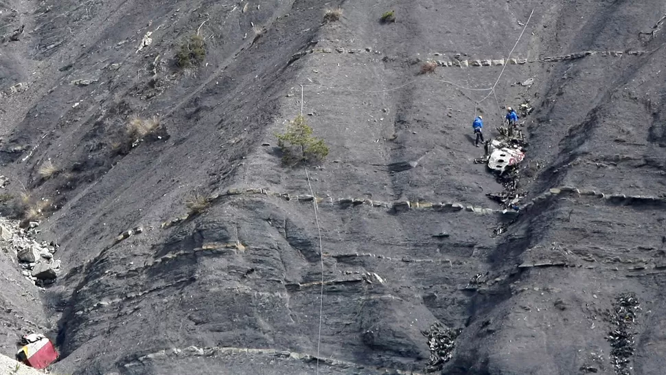 INTERMINABLE. Rescatistas recogen parten del avión que se estrelló en los Alpes franceses. REUTERS