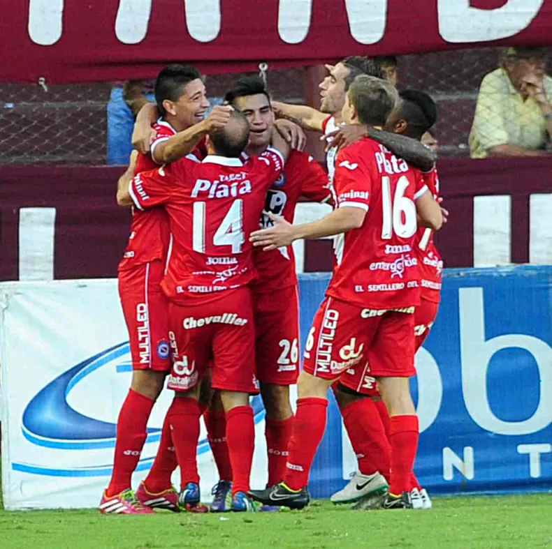 FESTEJO. Los jugadores de Argentinos abrazan a Rodríguez, autor del gol. télam