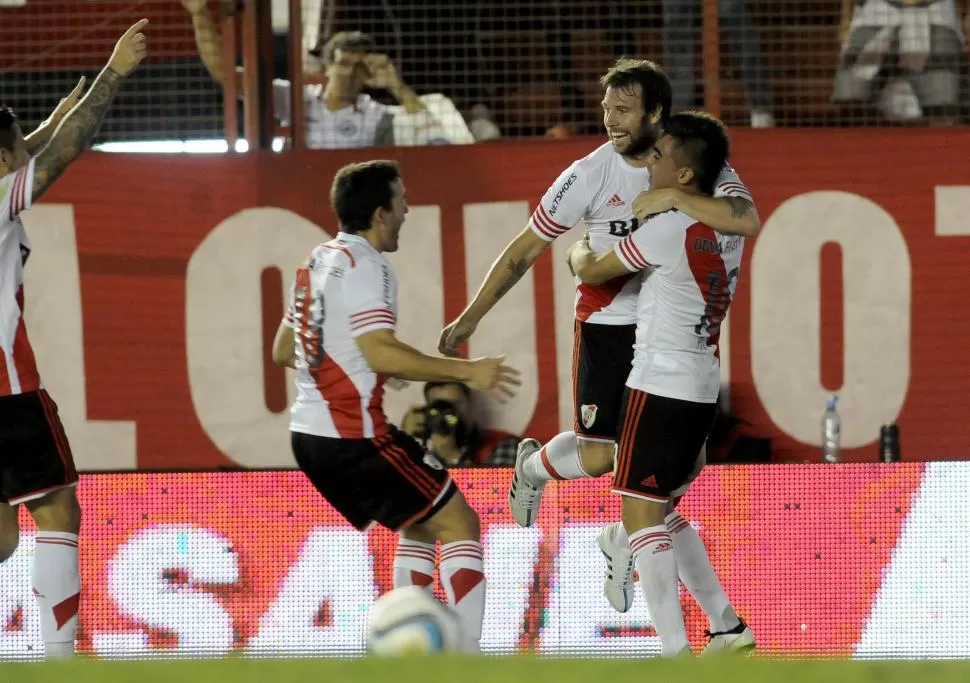 FESTEJO. Cavenaghi se trepa a Martínez y le sonríe a Mayada luego de anotar el primer gol del partido ante Argentinos.  dyn