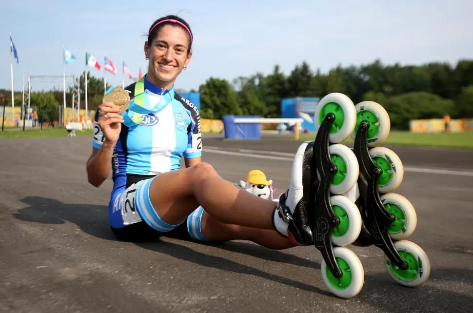 RUEDAS DORADAS. Arias luce con orgullo la presea de oro en plena pista. telam