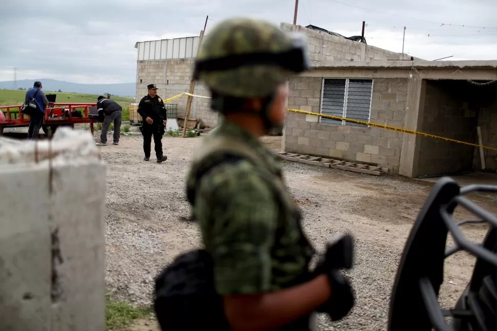 VIGILANCIA. Policías custodian un almacén, en donde está la salida del túnel por donde se fugó Guzmán.   