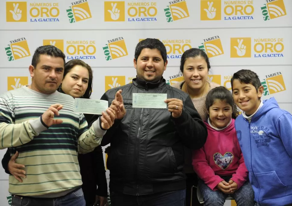 GANADORES. Daniel y Enzo con los cheques; aparecen María, la esposa del primero; Melisa, la mujer de Enzo; su hija Renata, y su sobrino Sebastián. LA GACETA / foto de J. P. Sánchez Noli