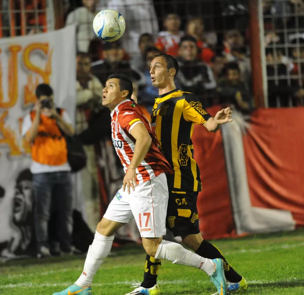 MUCHA LUCHA Y POCO FÚTBOL. Gonzalo Rodríguez cubre la pelota ante la marca de Jorge Scolari, ex defensor del “santo”. LA GACETA / FOTO DE hÉctor peralta