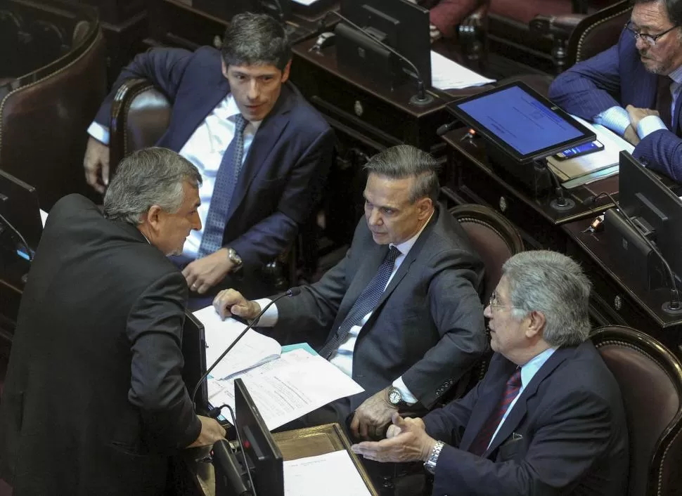 EN EL RECINTO. Gerardo Morales (presentó el proyecto) habla con Miguel Pichetto, del Frente para la Victoria, que pidió que el tema siga en estudio. telam