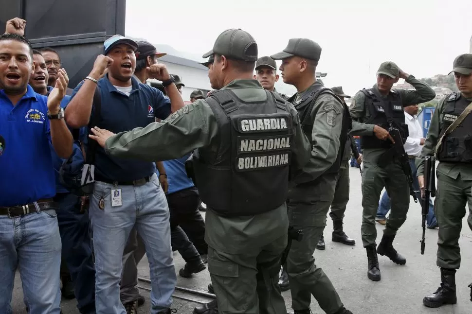 INCIDENTES. Trabajadores de la empresa Polar protestan por la ocupación de la planta y piden su reapertura, ante soldados de la Guardia Nacional reuters