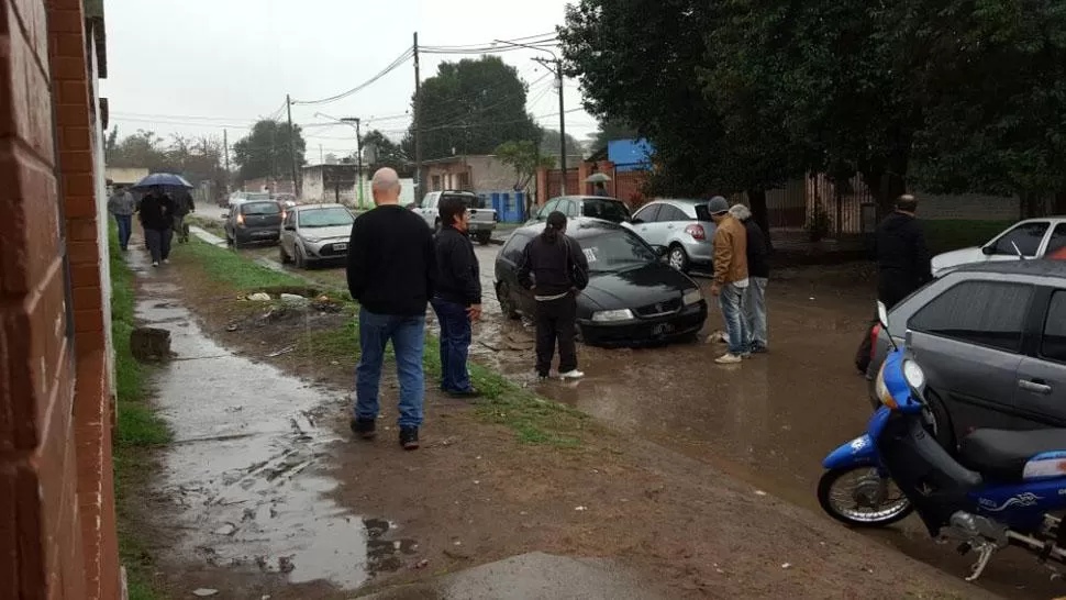 EN VILLA MUÑECAS. El anegamiento de una calle impidió detectar el pozo. LA GACETA / MIGUEL VELÁRDEZ