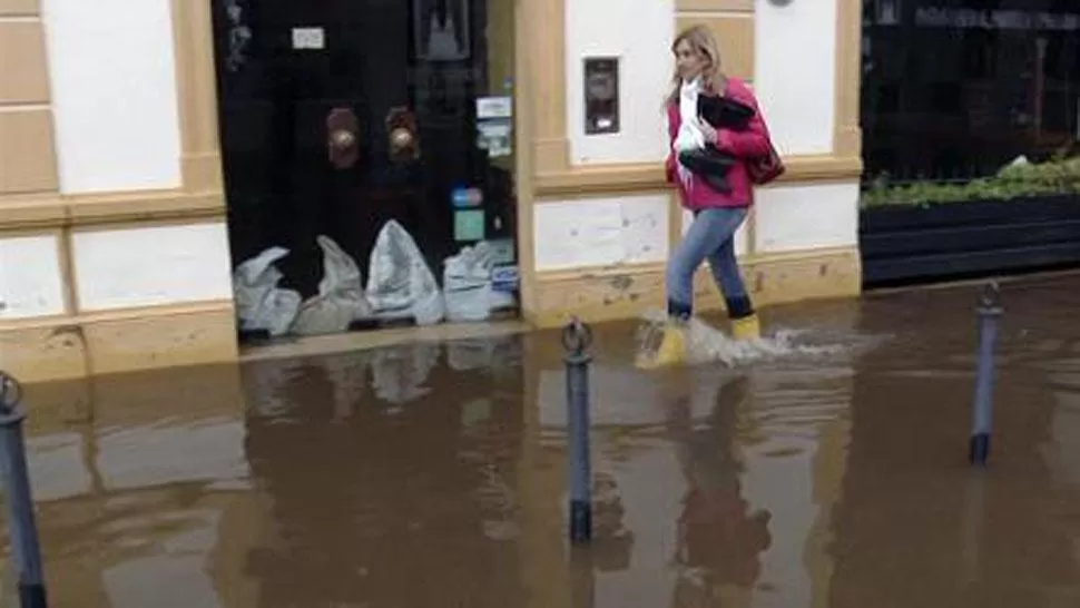 DESESPERADOS. Los vecinos de Luján buscan contener el avance del agua con bolsas de arena. FOTO TOMADA DE TN.COM.AR