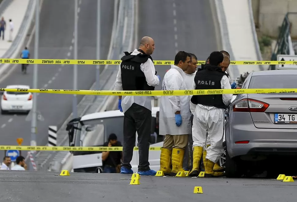 EN ESTAMBUL. Forenses y policías turcos examinan los daños producidos durante el ataque perpetrado contra una comisaría, con un auto-bomba. reuters