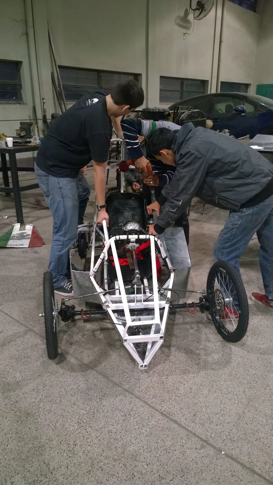 CONCENTRADOS. Chicos de la ENET 2 trabajan en detalles del coche. foto de luciano dulor 