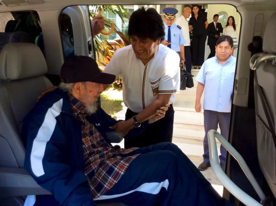 AYUDA. Evo Morales asiste a Castro para que baje de un vehículo. reuters