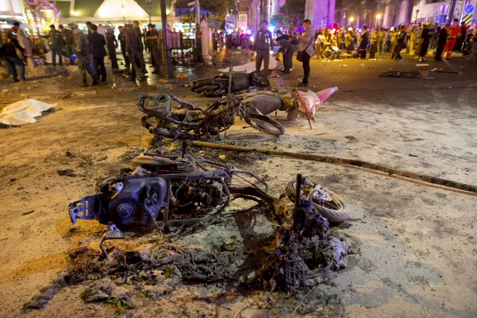 EL LUGAR. Restos de una motocicleta se observan frente al santuario de Erawan, en Bangkok. La bomba que estalló habría sido colocada en la moto. reuters