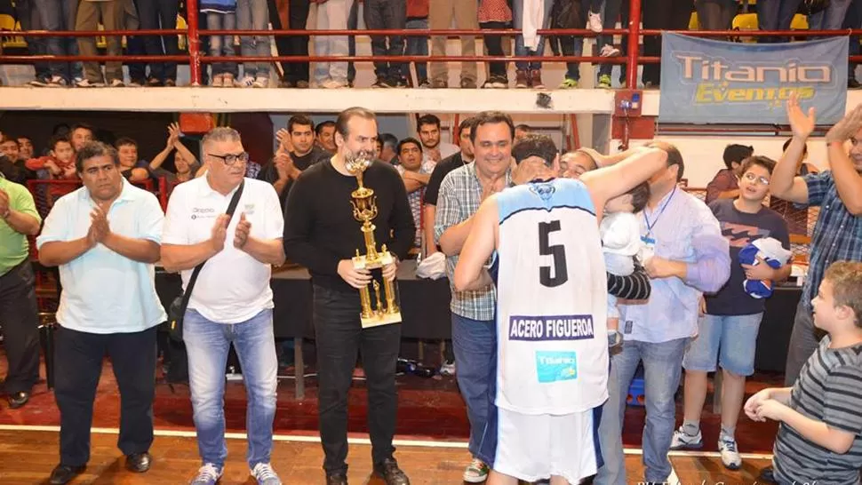 PREMICACIÓN. Susbielles, con el trofeo al campeón a Tucumán en sus manos para entregárselo al capitán José Muruaga.
FOTO TOMADA de basketucumano.com