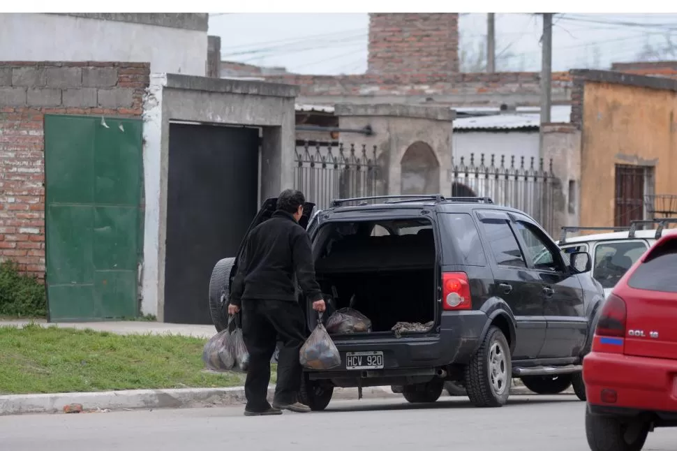 CARGAMENTO. Un hombre carga bolsones en una Ford en barrio Parque. la gaceta / fotos de inés quinteros orio