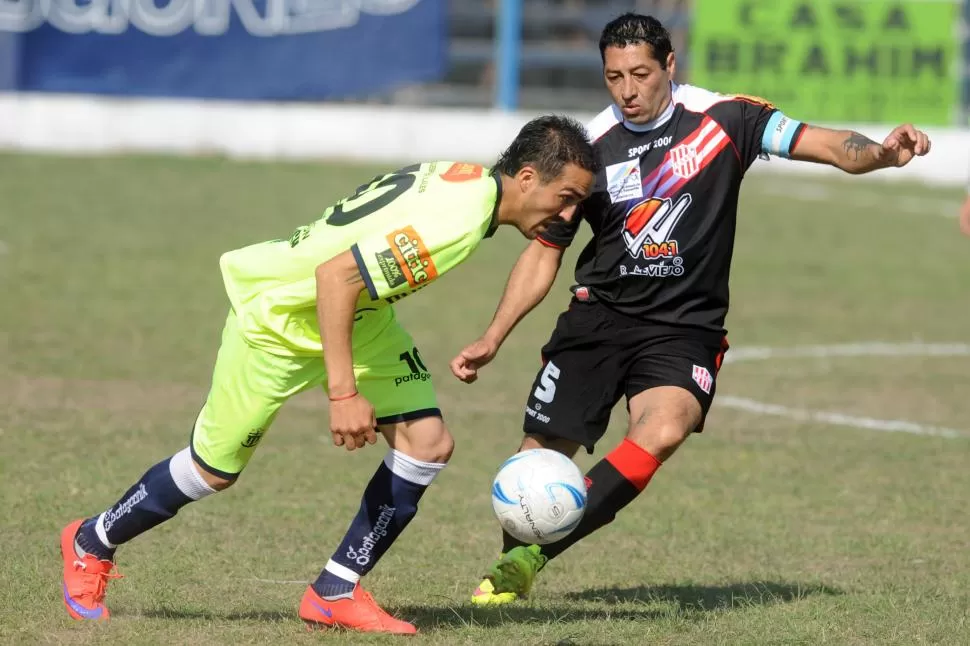 CON TODO AL ATAQUE. Daniel “Larry” Delgado, de Brown, se lleva la pelota ante la dura marca del capitán Carlos Rivero. LA GACETA / FOTO DE DIEGO ARÁOZ