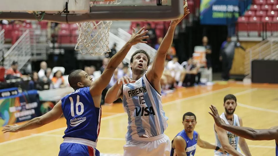 BUEN APORTE. Marcos Delía anotó 10 puntos y tomó seis rebotes. En la acción, trata de convertir ante la marca de Dagoberto Pena.
FOTO TOMADA DE Fibaamericas.com