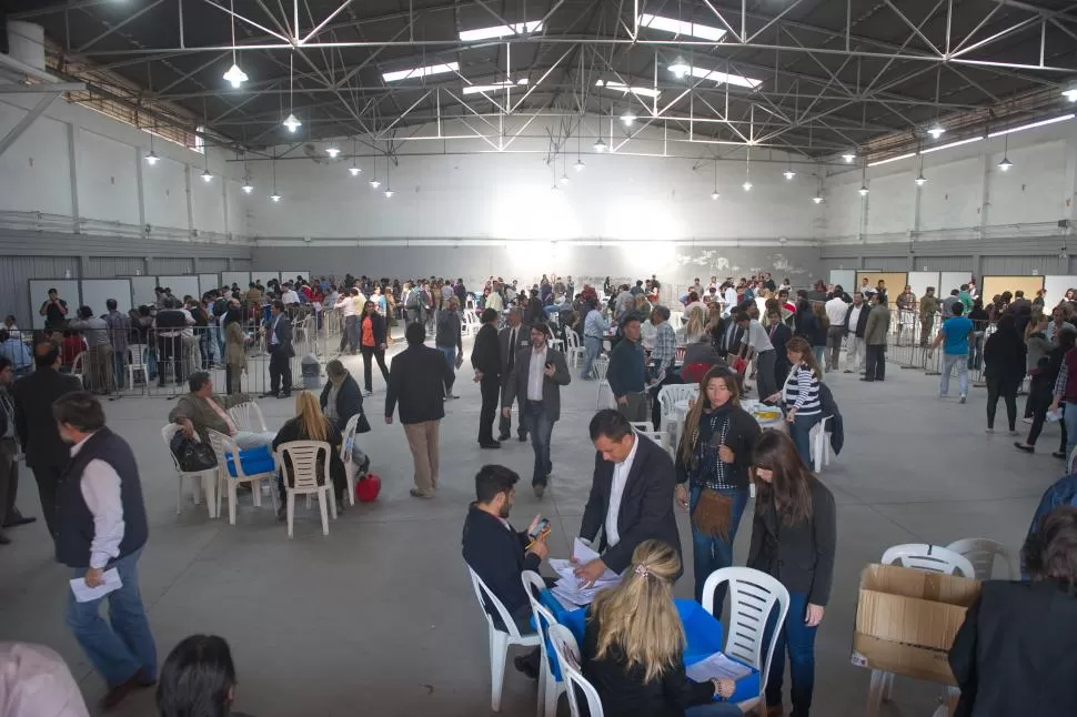 ARDUA TAREA EN CALLE MENDOZA 1050. Los apoderados partidarios, separados en grupos, trabajan en el conteo definitivo de boletas, en la sede de la Junta Electoral. En los boxes, al fondo, autoridades de la JEP exponen datos oficiales. la gaceta / fotos de juan pablo sánchez noli