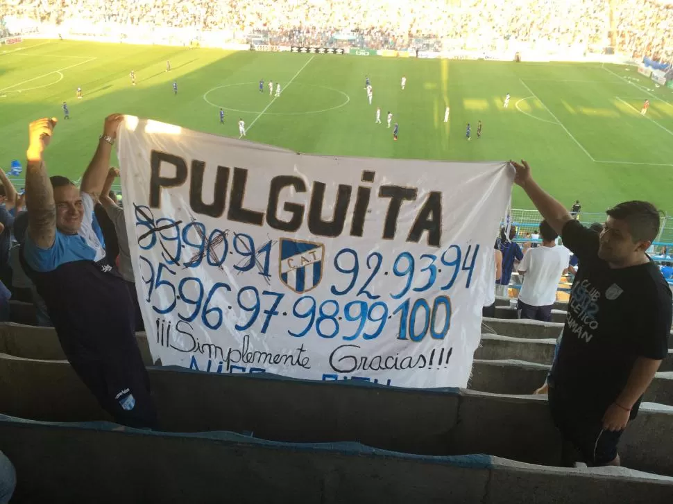 CUENTA REGRESIVA. Dos hinchas lucen orgullosos la bandera donde marcarán los goles de Luis Miguel Rodríguez. Al delantero le faltan 9 para llegar a los 100.  la gaceta / foto de nicolás iriarte